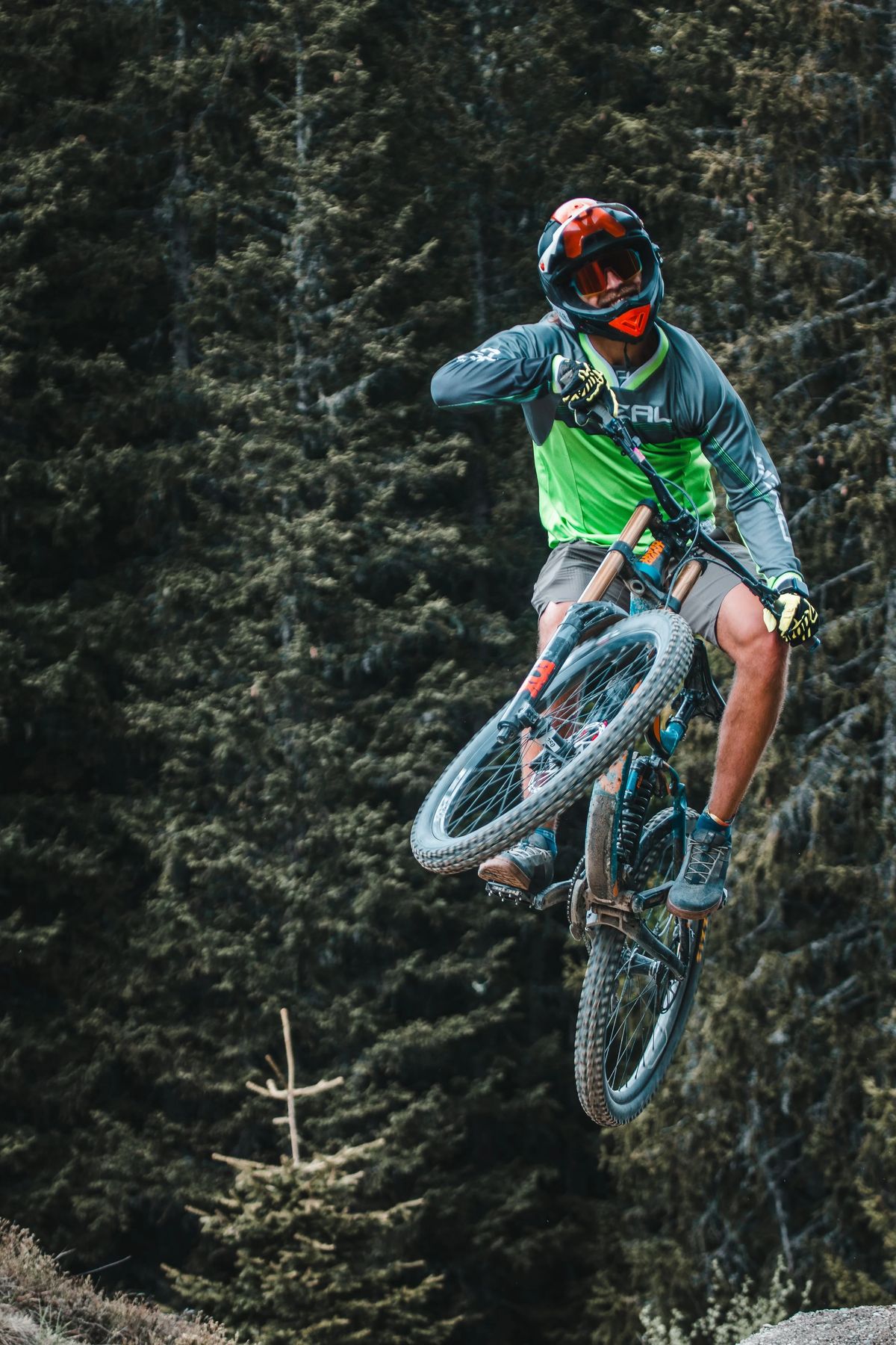 Lucas Kampf springt mit dem Mountainbike zwischen Tannen