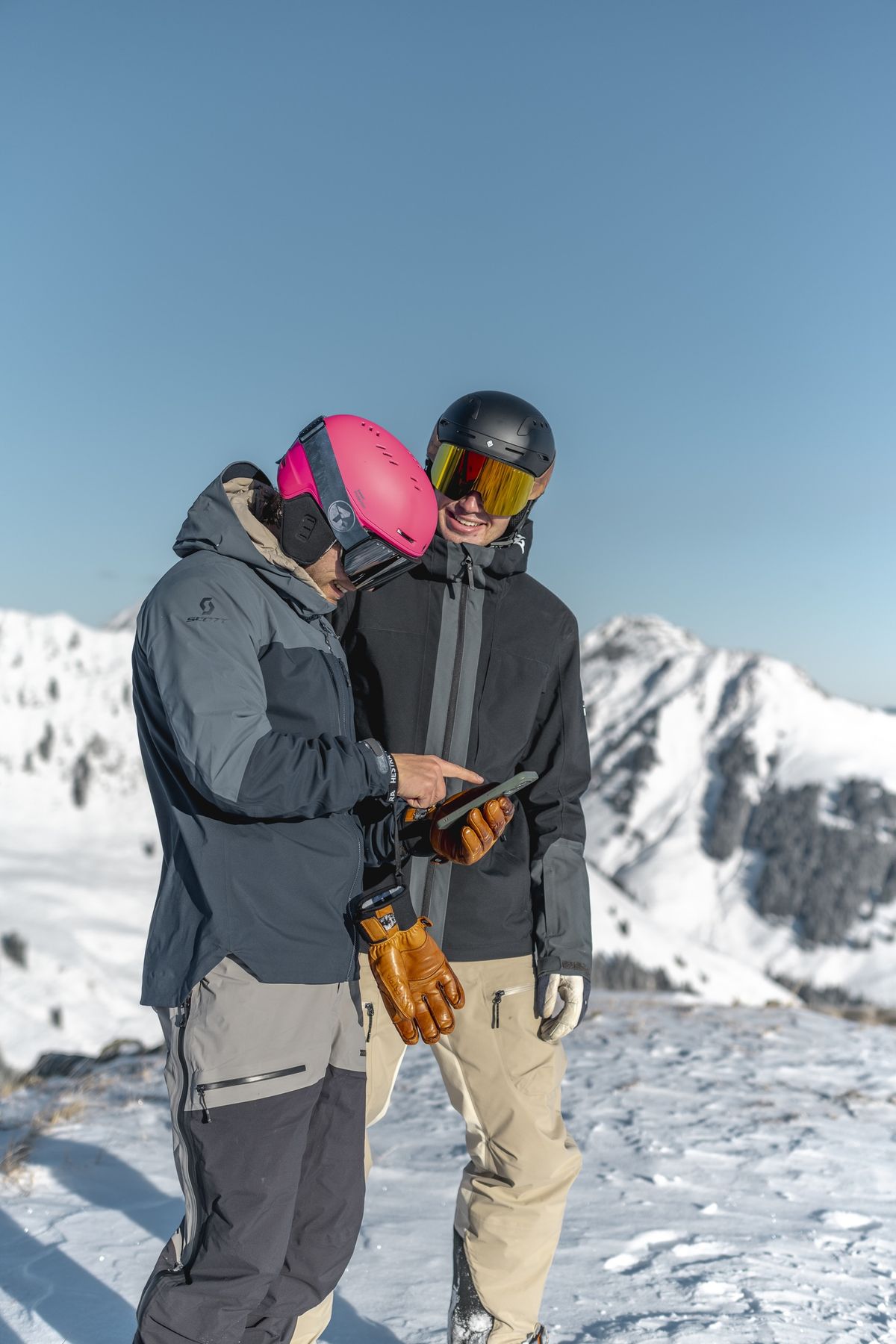 Lucas Kampf und ein Kollege in Skikleidung schauen gemeinsam aufs Handy